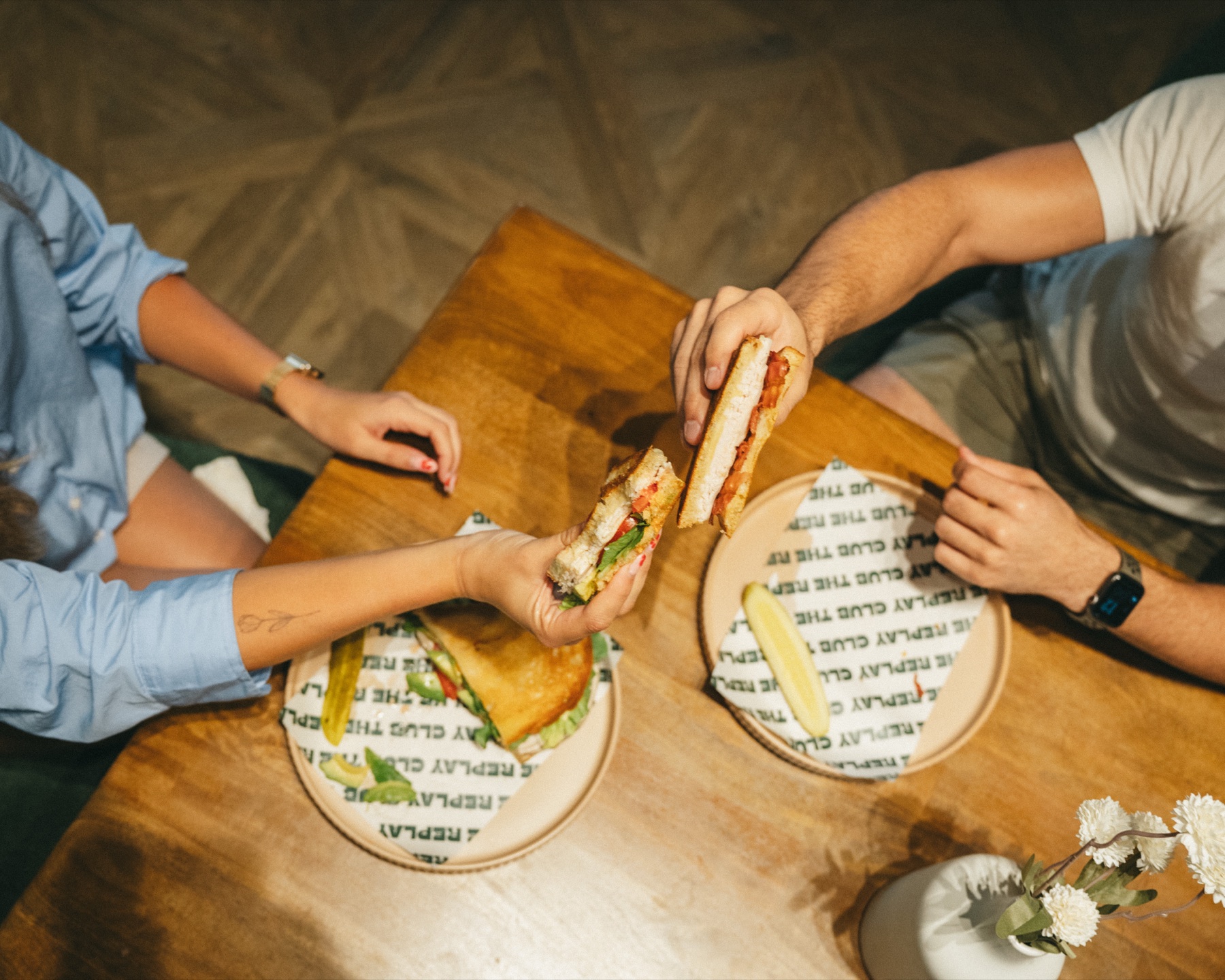 Replay Club members sharing sandwiches in the lounge