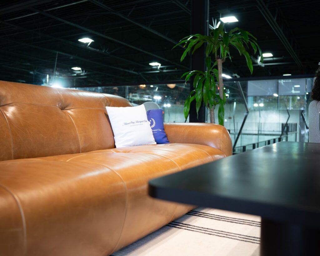 A couch, table, and potted plant in a luxuriously furnished lounge at Replay Club.