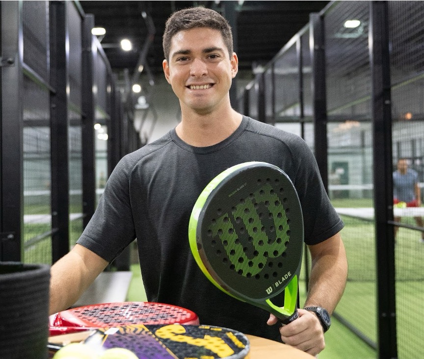 A member of Replay Club playing padel in a climate-controlled court