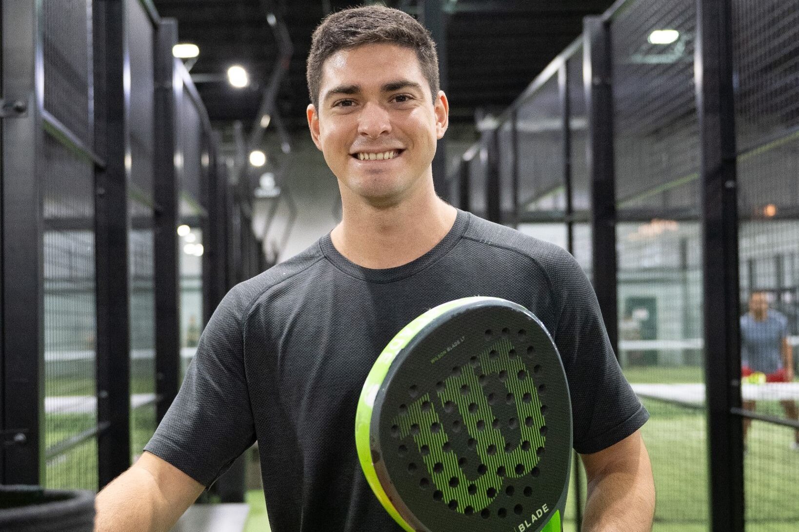 A member of Replay Club playing padel in one of the indoor, climate-controlled courts.